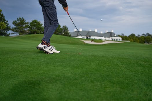 A golfer mid-swing on a beautiful green golf course in Oberwaltersdorf, Austria.